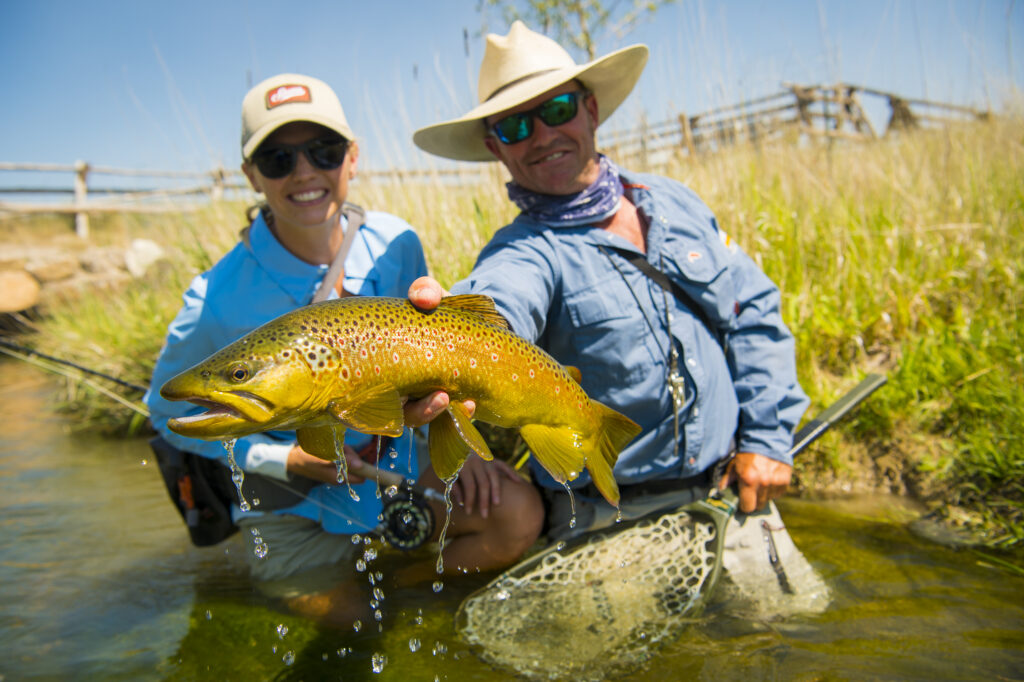 guide holding a trout for angler